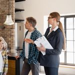 A family converses with a real estate agent about a modern home interior.