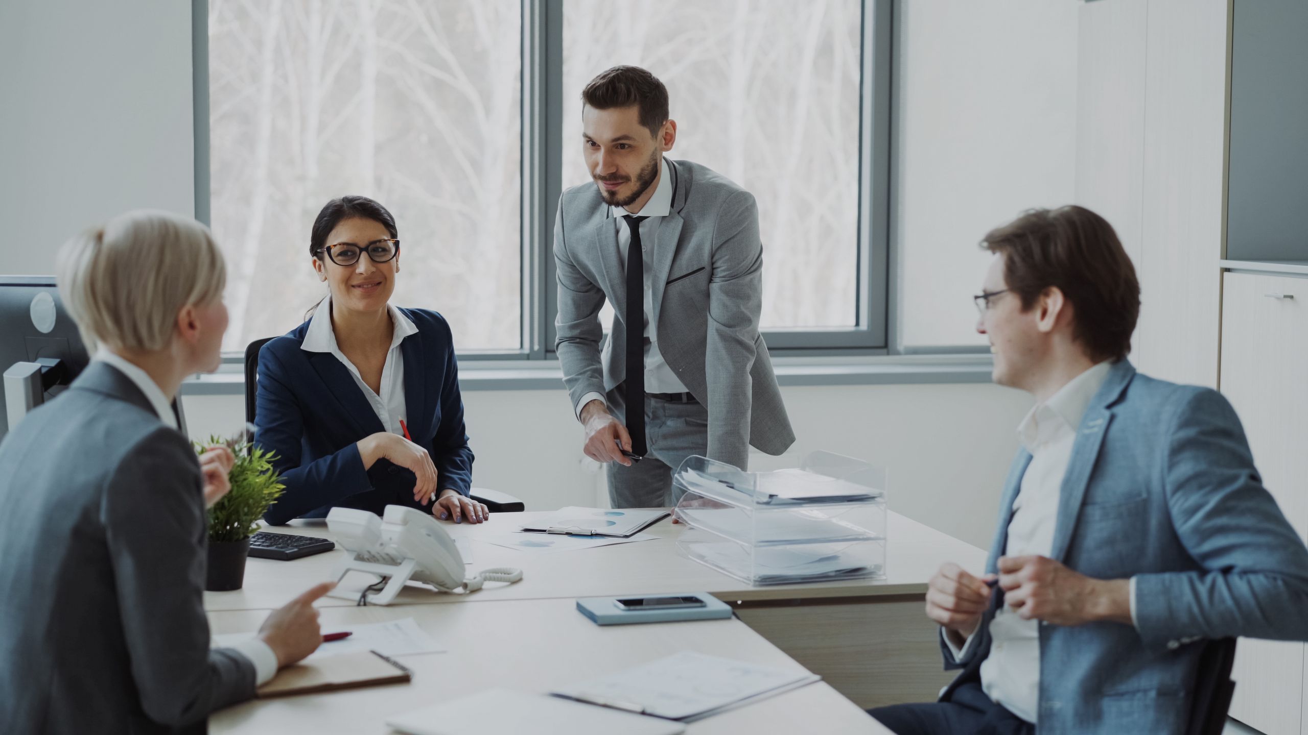 Group of professionals in a modern office setting discussing business strategies.